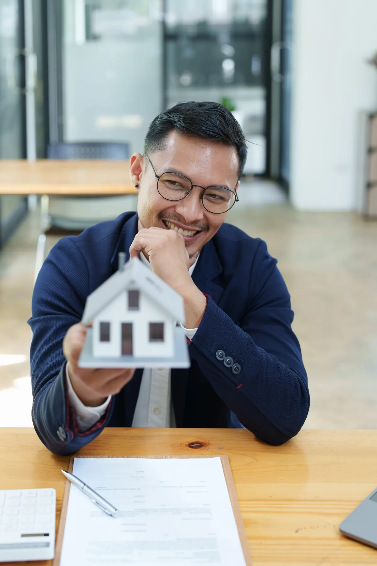 Happy homeowner holding a house model